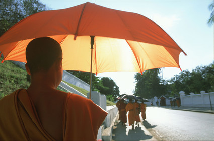 LAOS, MOINES AVEC PARAPLUIE DANS LES RUES DE LUANG PRABANG.