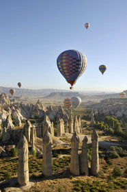 Turkey, Central Anatolia, Nevsehir Province, Cappadocia listed as World Heritage by UNESCO, hot air baloon flying over an eroded landscape and fairy chimneys near Goreme, love valley